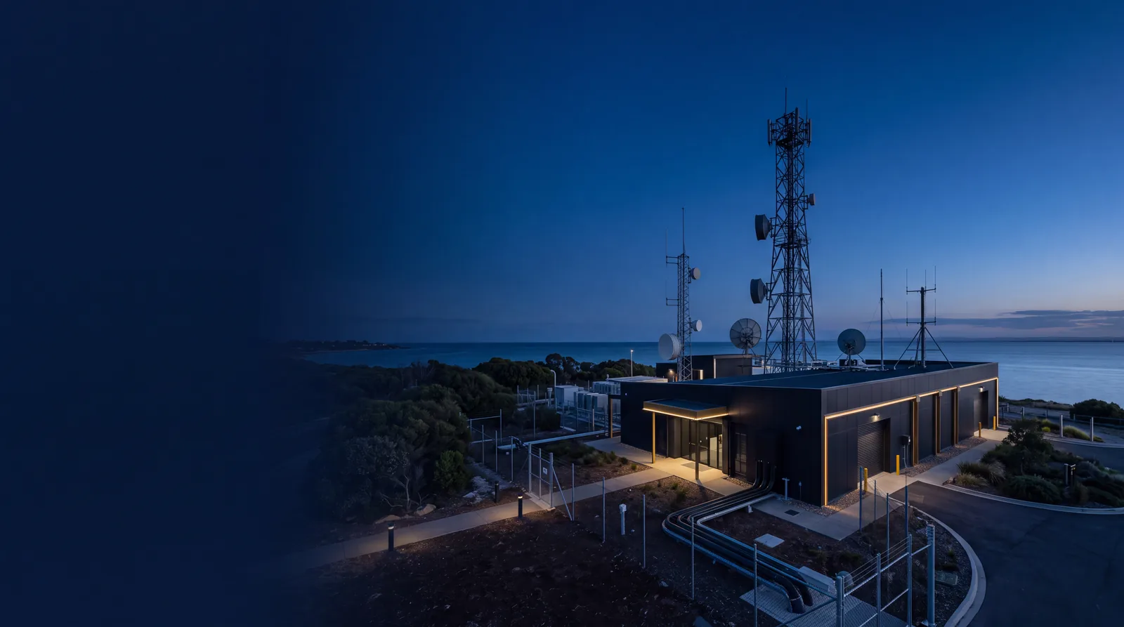 Fiber landing station and communications tower at dusk